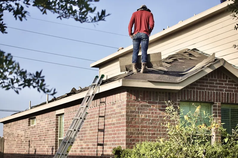 Professional roofer working on a residential roof in Elkins Park House